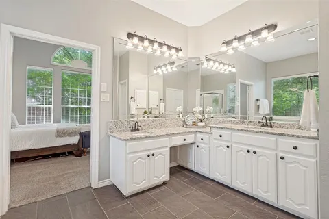 a spacious bathroom with a double vanity sink a large mirror and a bathtub