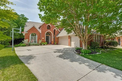 a front view of a house with a yard and trees