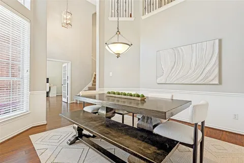 a room with table chairs and wooden floor