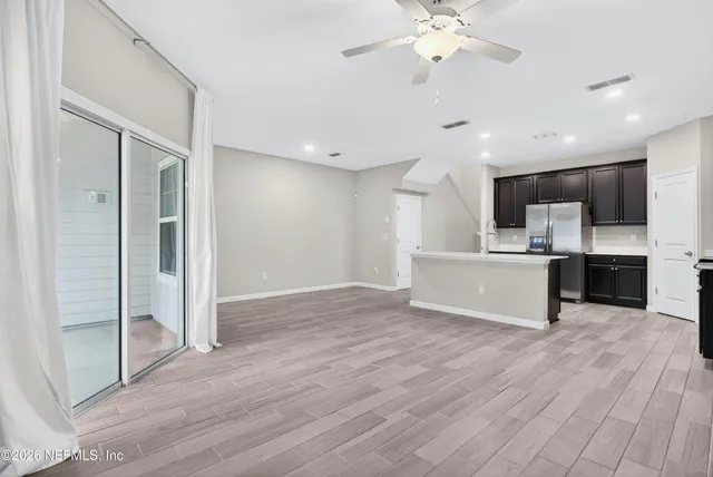 a view of kitchen with granite countertop cabinets and refrigerator