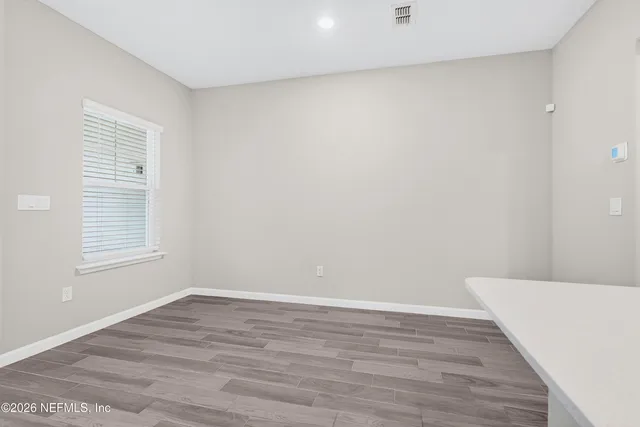 a view of a room with wooden floor and window