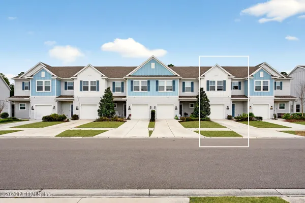 a view of house with a big yard and large trees