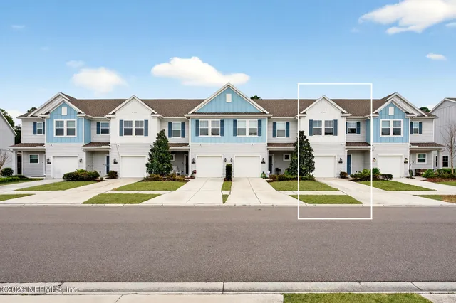 a view of house with a big yard and large trees