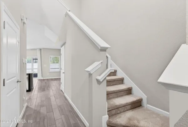 a view of entryway and hall with wooden floor