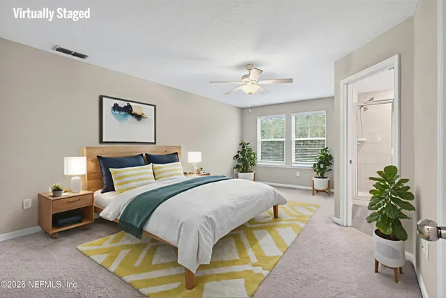 a spacious bedroom with a bed a chandelier and a window