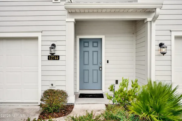 a view of front door and a potted plant