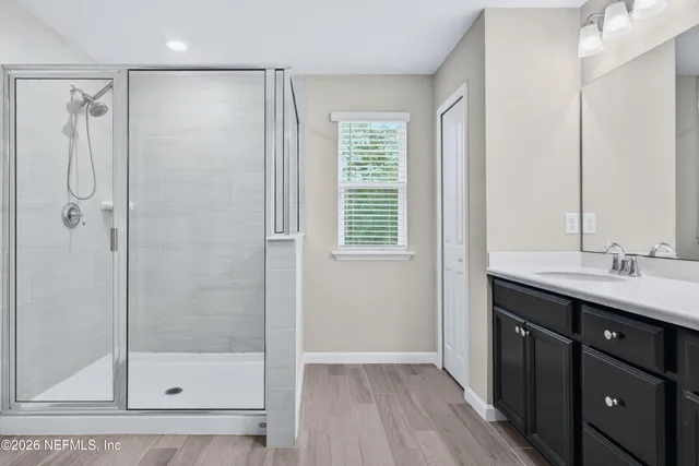 a bathroom with a shower sink and mirror