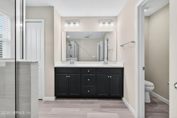 a bathroom with a double vanity sink and a mirror