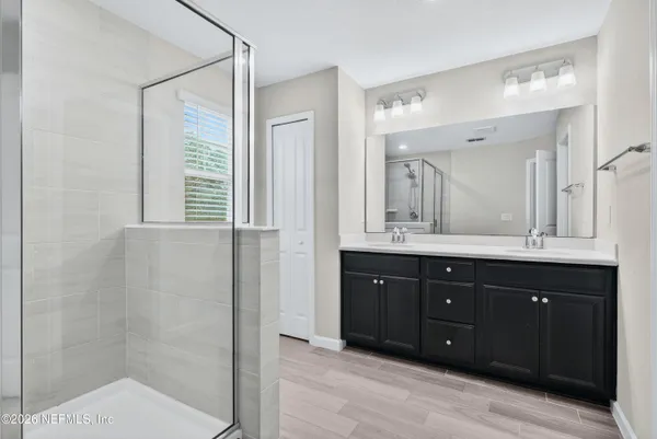 a bathroom with a granite countertop sink a mirror and a shower