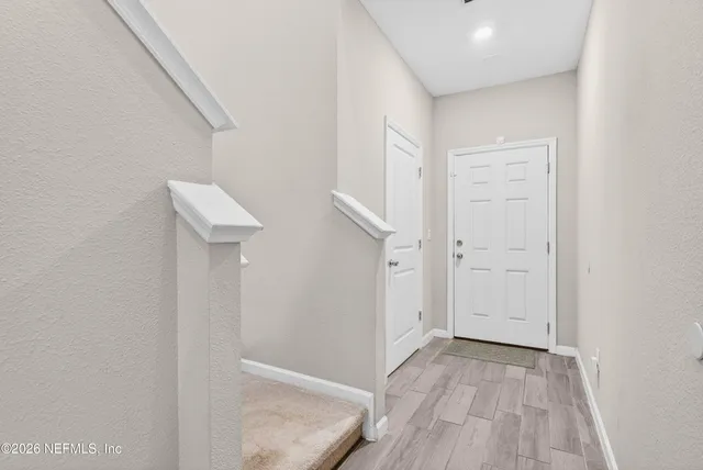 a view of a hallway with wooden floor and entryway
