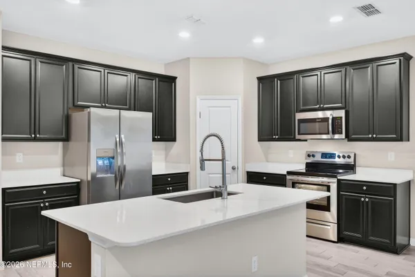 a kitchen with stainless steel appliances a refrigerator stove microwave and sink