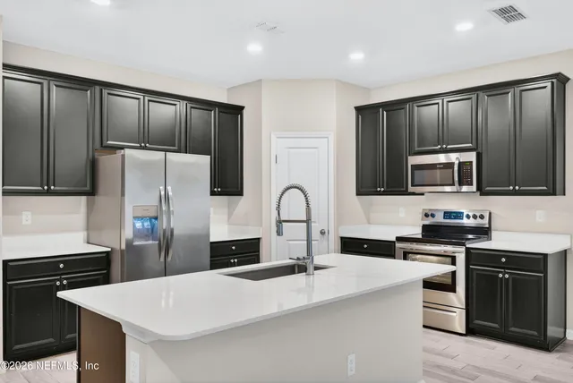 a kitchen with stainless steel appliances a refrigerator stove microwave and sink