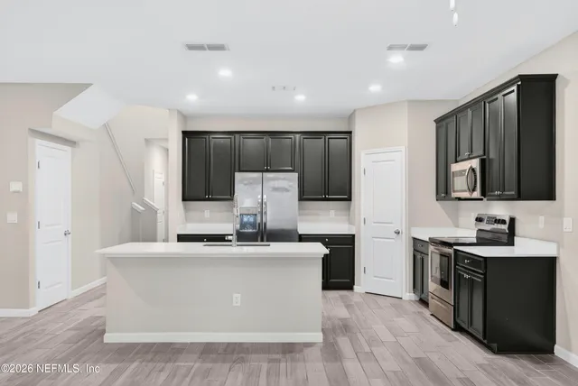 a kitchen with stainless steel appliances a sink and a refrigerator