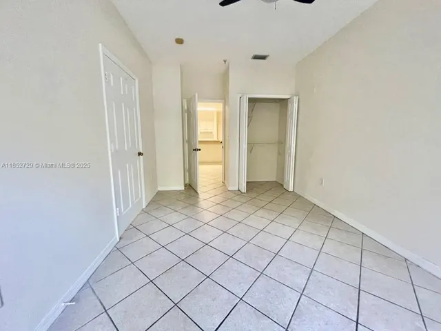 a view of a livingroom with a chandelier fan and windows