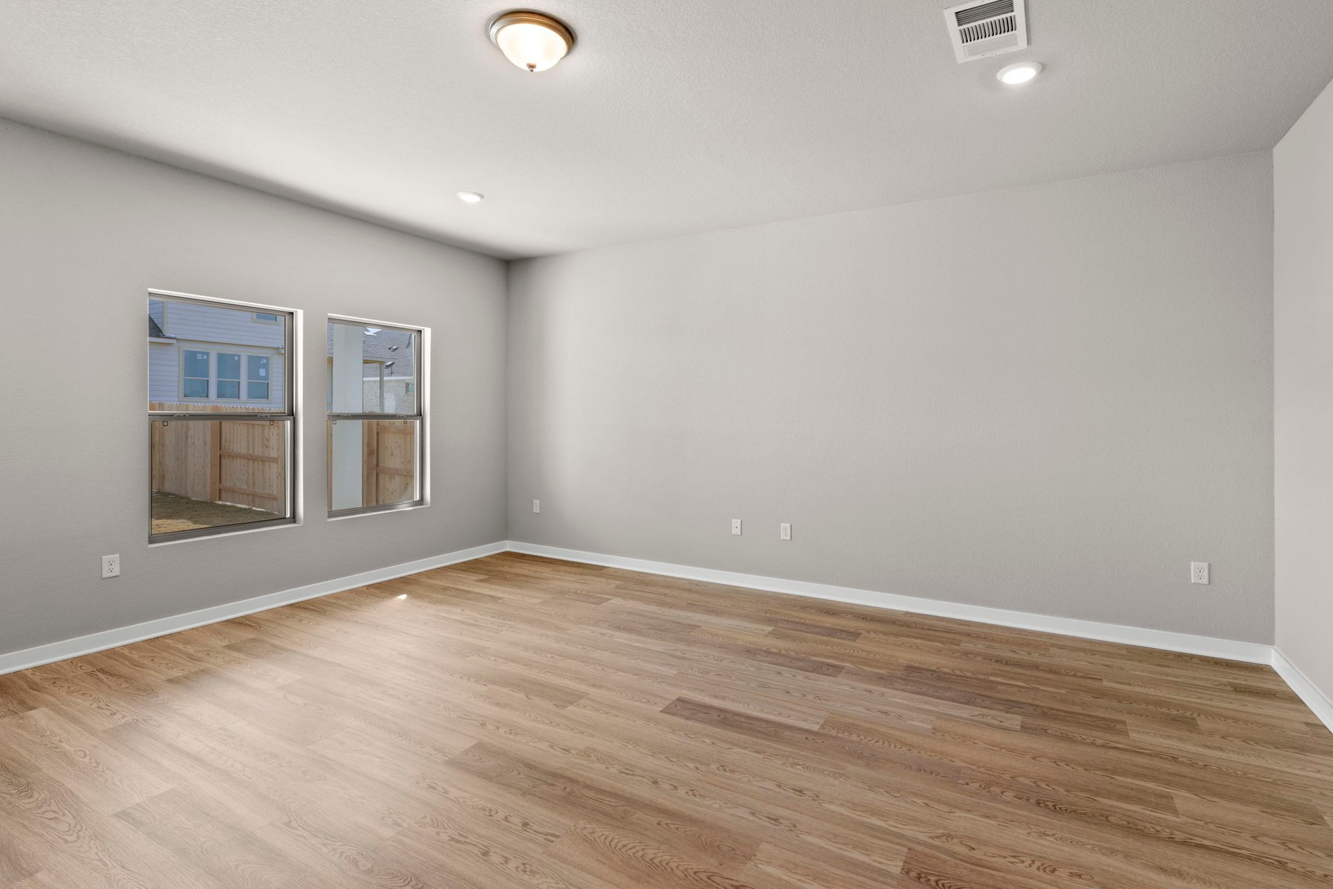 13613 Gray Landing Drive Elgin, TX 78621 - Photo 14 of 33 an empty room with wooden floor and windows