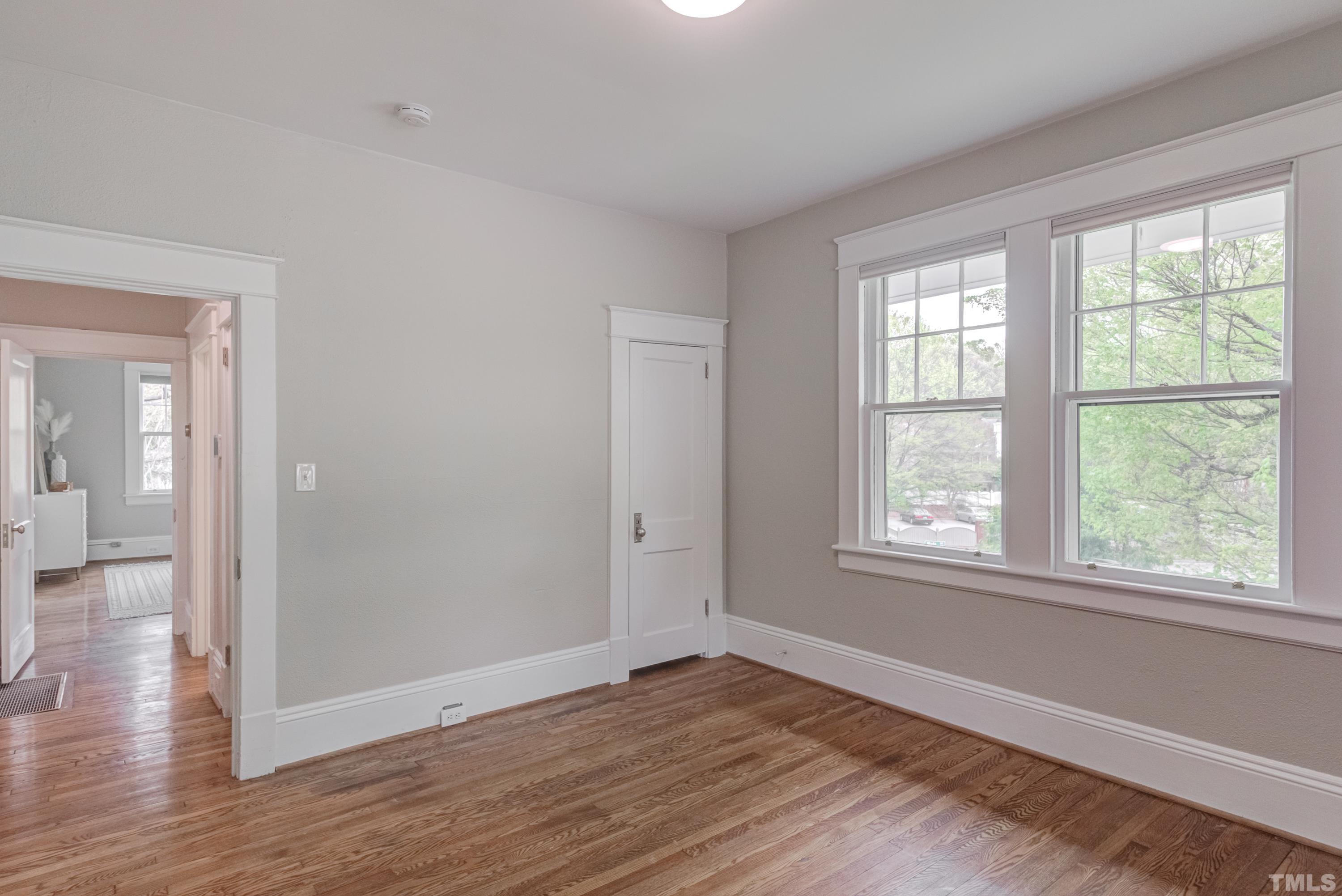 402 Cole Street Raleigh, NC 27605 - Photo 21 of 39 a view of an empty room with wooden floor and a window