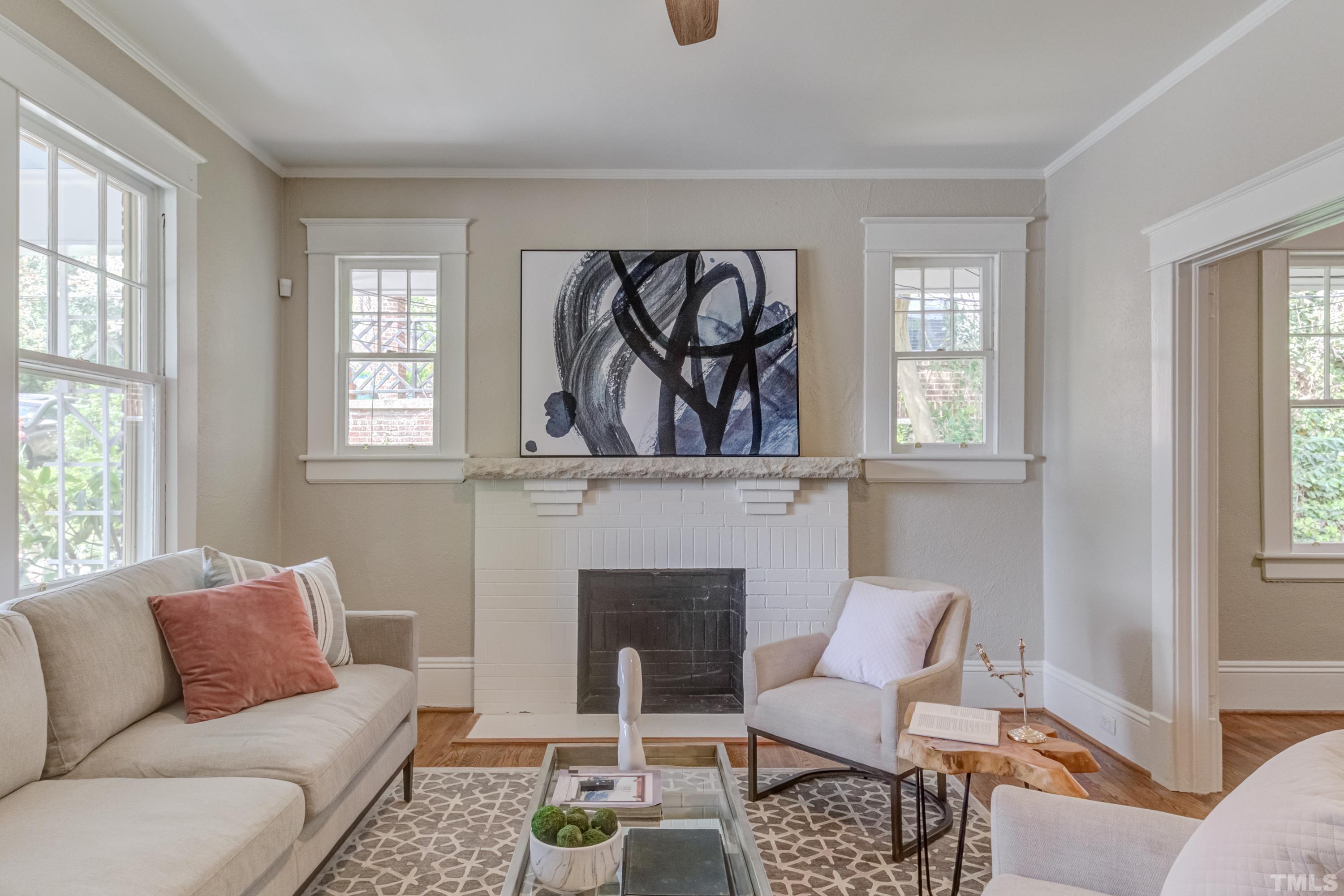 402 Cole Street Raleigh, NC 27605 - Photo 5 of 39 a living room with furniture a rug a window and a fireplace