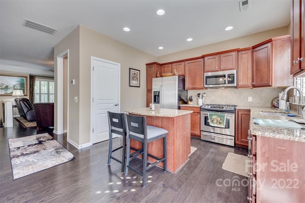 1112 Drayton Court Fort Mill, SC 29708 - Photo 13 of 27 a kitchen with stainless steel appliances granite countertop a stove top oven a sink dishwasher a dining table and chairs with wooden floor