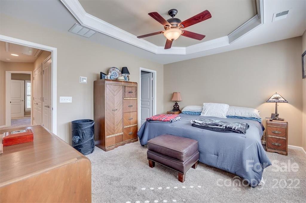 1112 Drayton Court Fort Mill, SC 29708 - Photo 19 of 27 a bedroom with a bed and a chandelier