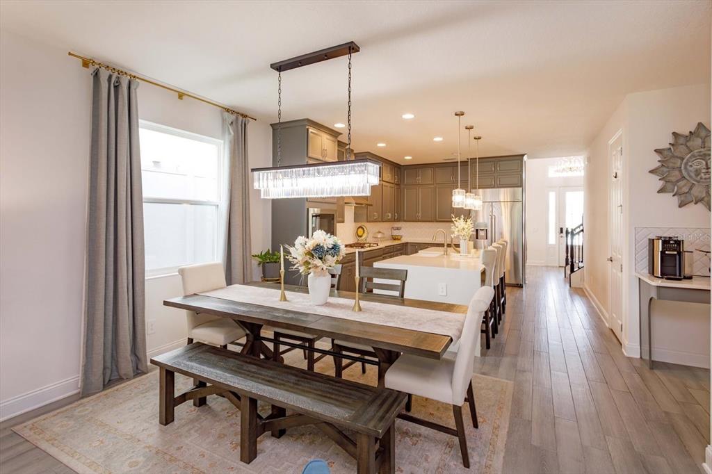 1231 Foltz Loop Oakland, FL 34787 - Photo 12 of 30 a kitchen with kitchen island a dining table chairs and a wooden floor