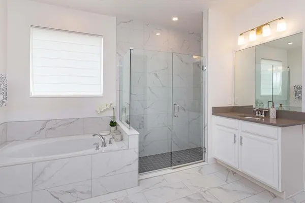 a bathroom with a granite countertop sink a mirror and a bathtub