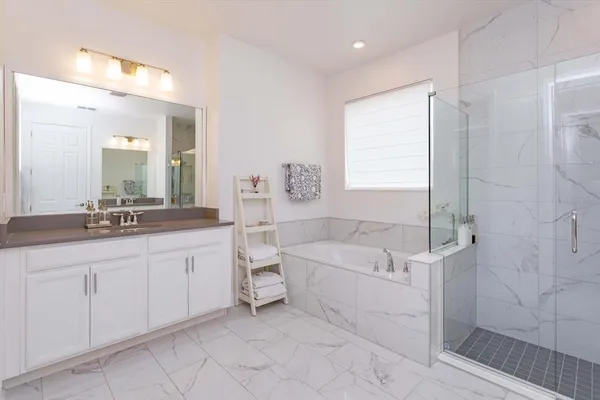 a bathroom with a double vanity sink a toilet a mirror and shower