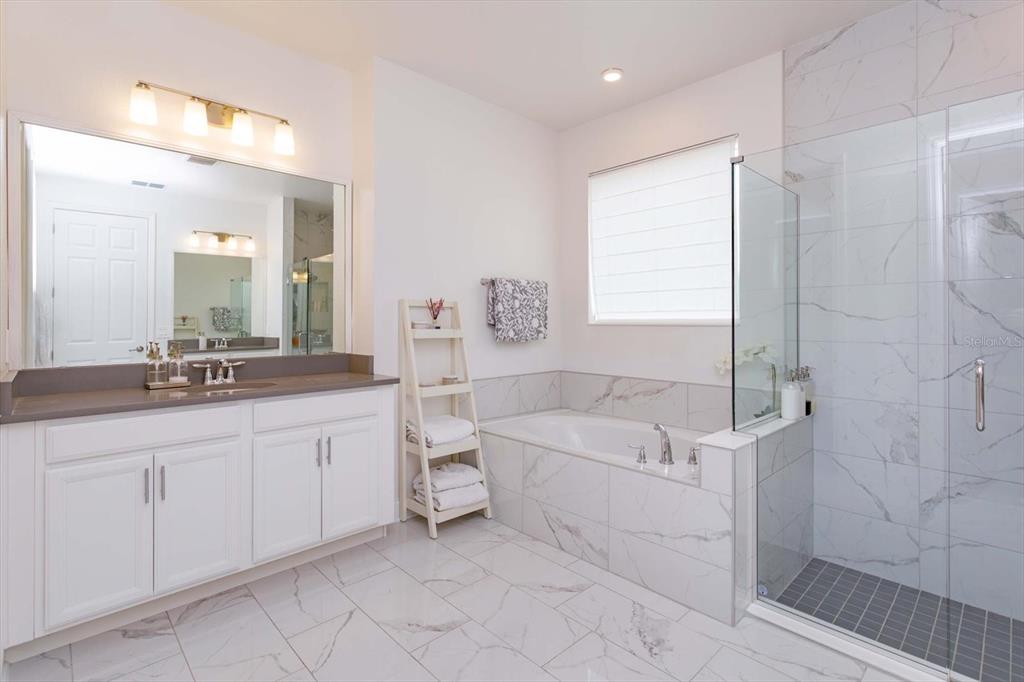 1231 Foltz Loop Oakland, FL 34787 - Photo 18 of 30 a bathroom with a double vanity sink a toilet a mirror and shower