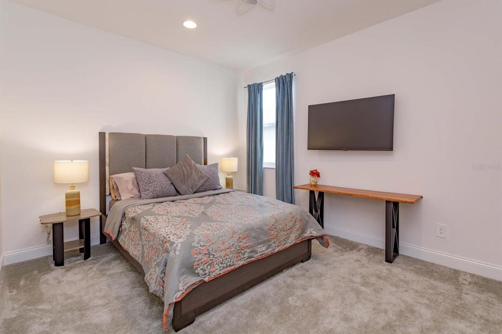 1231 Foltz Loop Oakland, FL 34787 - Photo 19 of 30 a bedroom with a bed and a flat screen tv