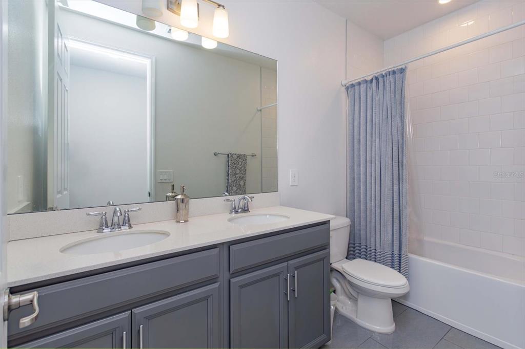 1231 Foltz Loop Oakland, FL 34787 - Photo 20 of 30 a bathroom with a sink a toilet a mirror and shower