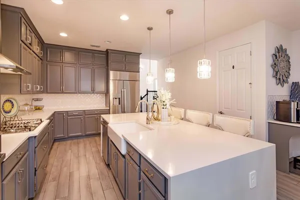a large kitchen with kitchen island a large counter space a sink appliances and cabinets