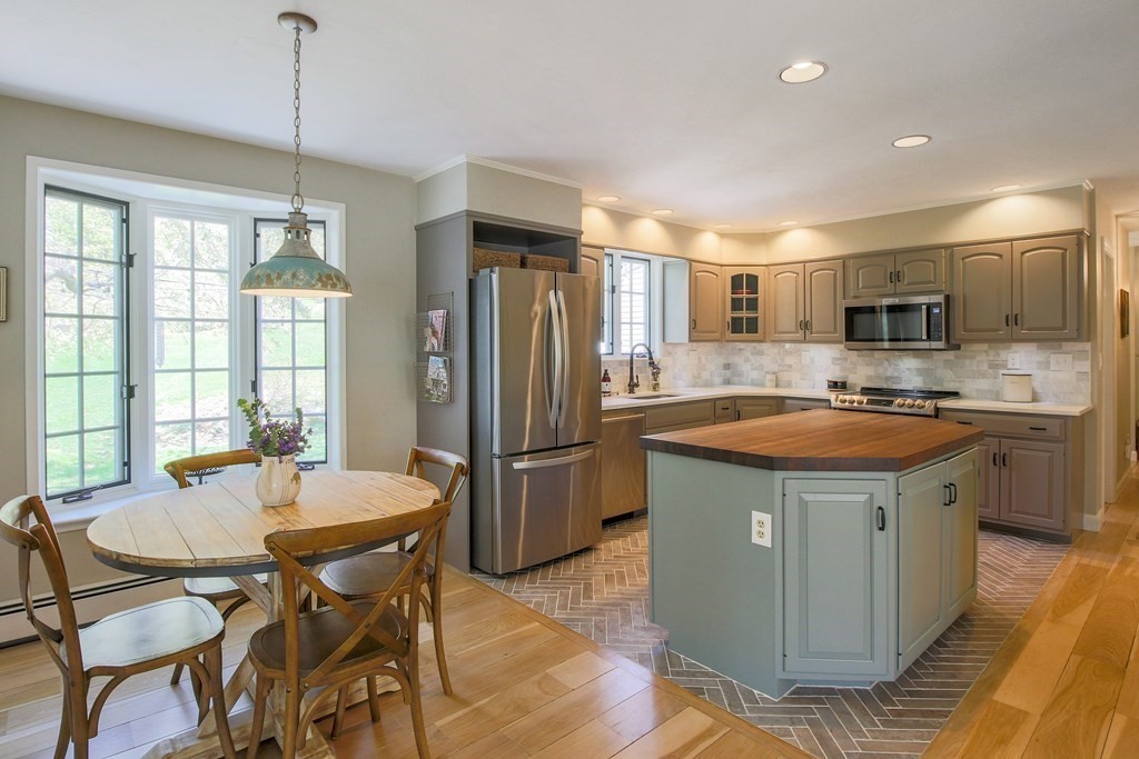 235 Mirick Road Princeton, MA 01541 - Photo 6 of 42 a kitchen with a table chairs refrigerator and microwave