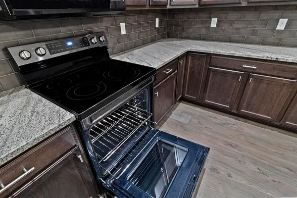 a stove top oven sitting inside of a kitchen
