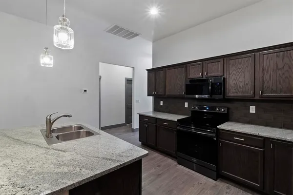 a kitchen with granite countertop stainless steel appliances and wooden cabinets