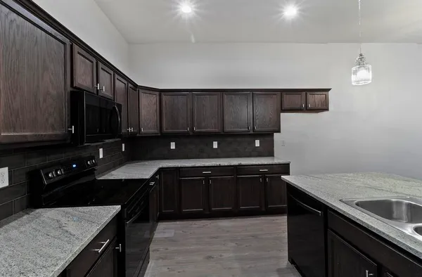 a kitchen with stainless steel appliances granite countertop a sink stove and cabinets