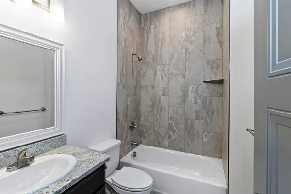 a bathroom with a granite countertop sink toilet and shower