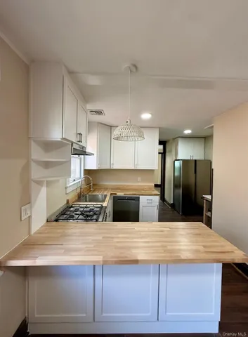 a large kitchen with a center island and stainless steel appliances