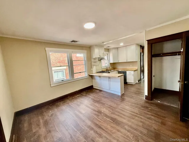 a view of a kitchen with kitchen island a sink wooden floor and a window