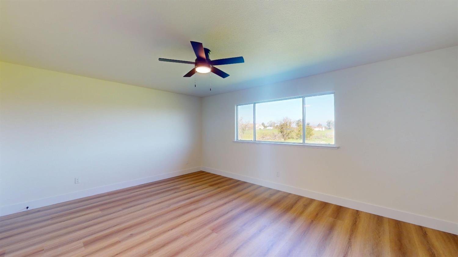 16363 Paula Road Madera, CA 93636 - Photo 15 of 29 a view of empty room with wooden floor and fan