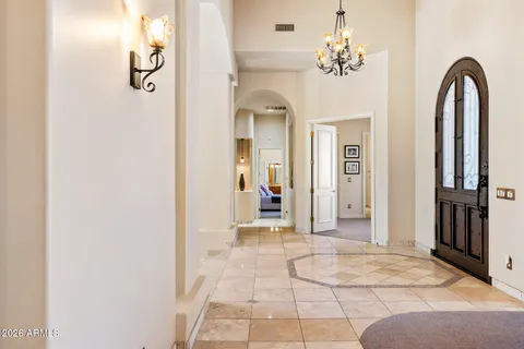 a view of a hallway with windows and chandelier