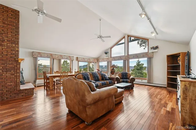 a living room with furniture large window and wooden floor