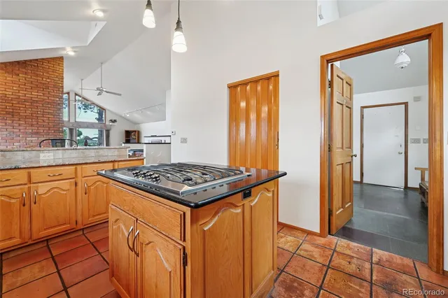 a kitchen with stainless steel appliances granite countertop a table chairs and a refrigerator