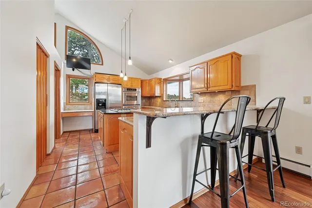 a kitchen with stainless steel appliances granite countertop a stove a sink and a microwave