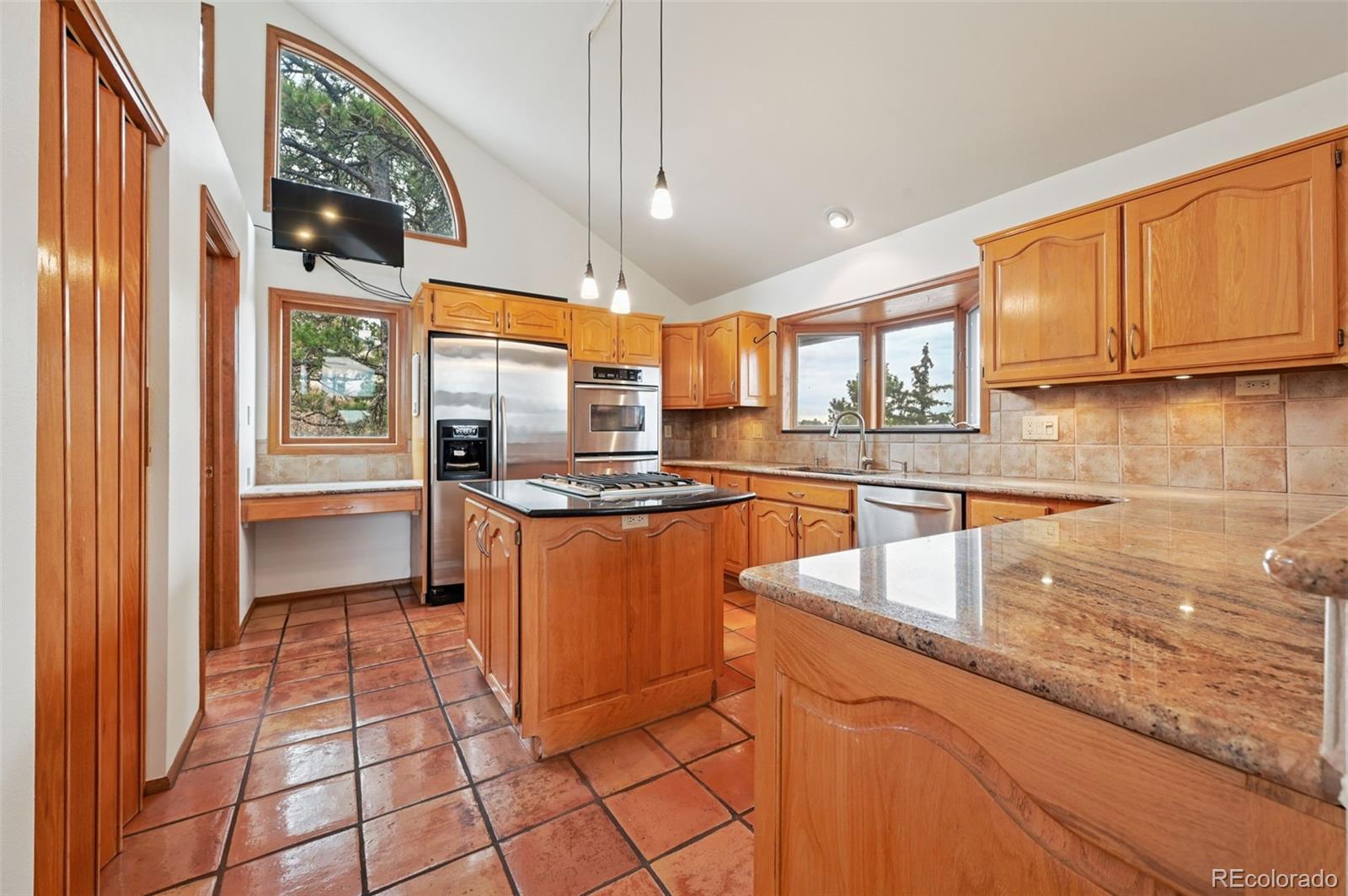 17580 Chipped Arrow Way Monument, CO 80132 - Photo 22 of 47 a kitchen with stainless steel appliances granite countertop a stove a sink and a microwave