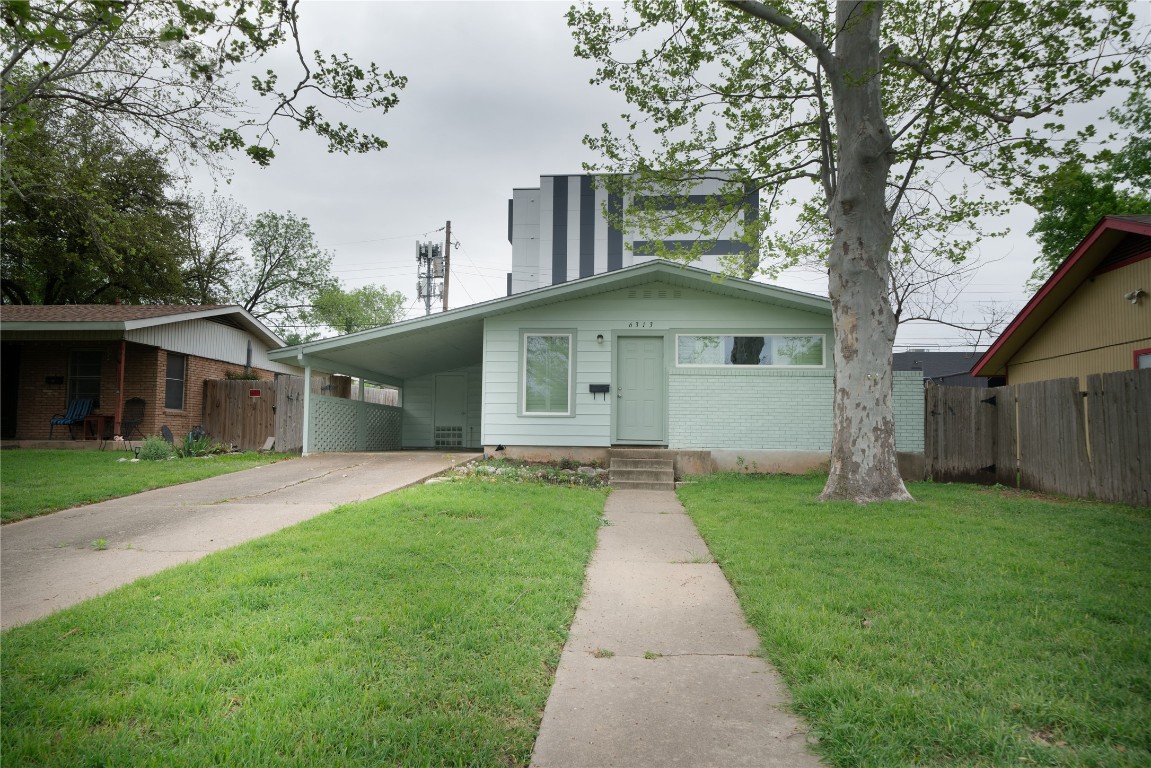 6313 Wild Street Austin, TX 78752 - Photo 1 of 32 a front view of a house with yard