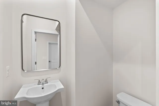 a bathroom with a toilet a sink and mirror