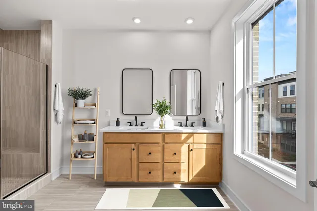 a large bathroom with a double vanity sink a mirror and a shower
