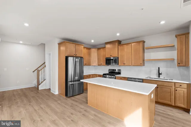 a kitchen with stainless steel appliances a refrigerator sink and microwave