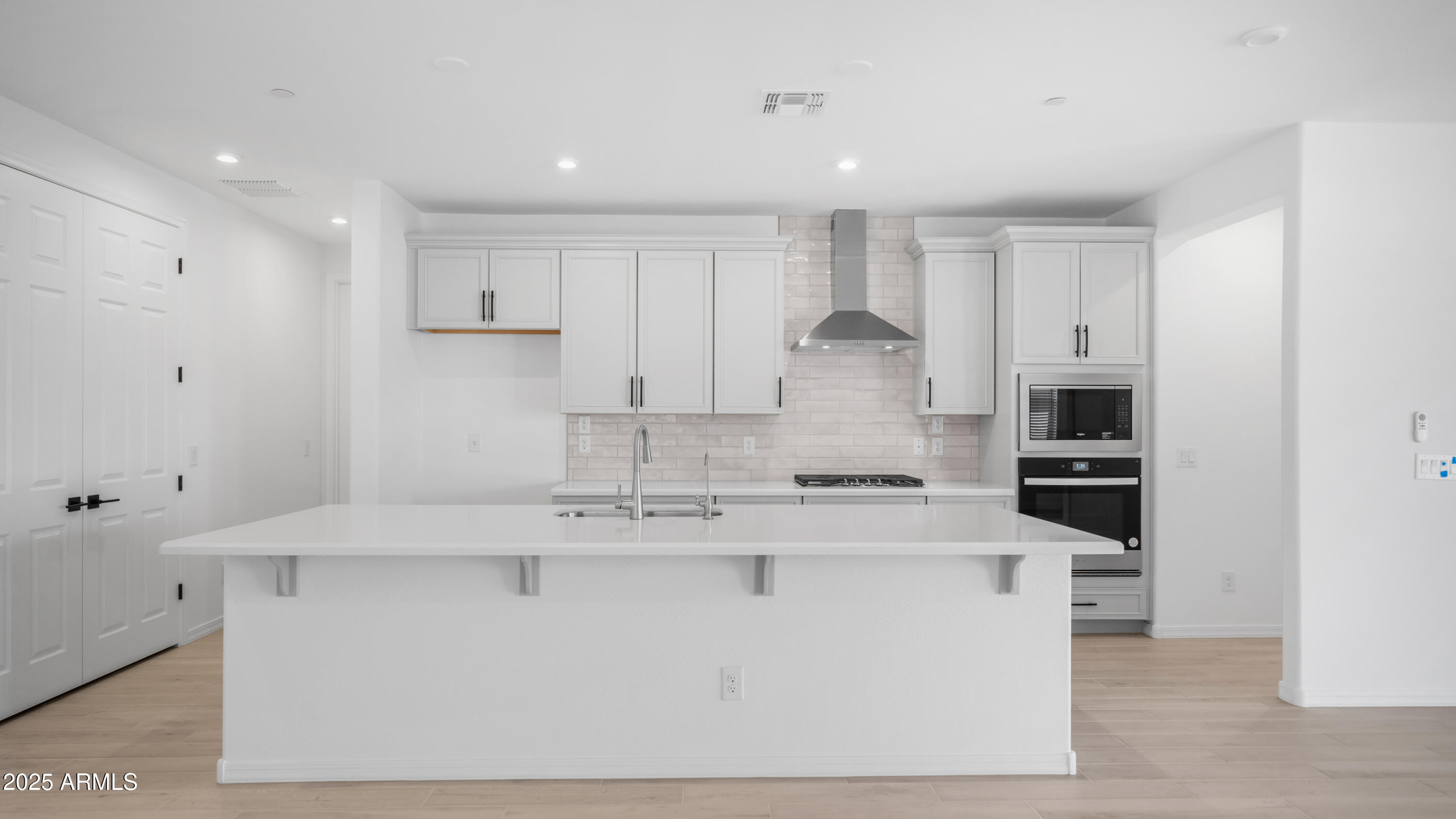 13362 West Eagle Feather Road Peoria, AZ 85383 - Photo 14 of 32 a large kitchen with stainless steel appliances granite countertop a white stove top oven and white cabinets
