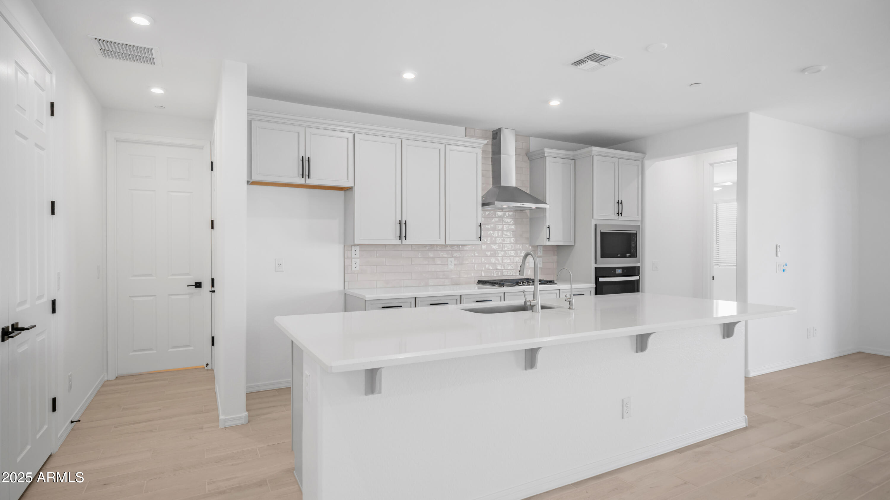 13362 West Eagle Feather Road Peoria, AZ 85383 - Photo 15 of 32 a kitchen with a sink a stove a refrigerator and white cabinets