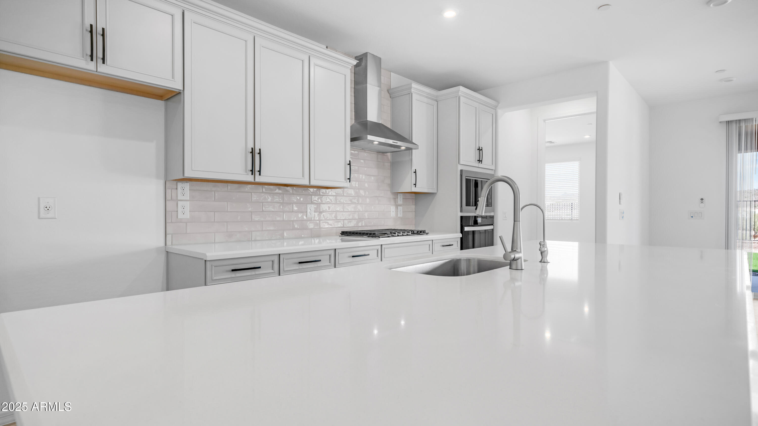 13362 West Eagle Feather Road Peoria, AZ 85383 - Photo 16 of 32 a kitchen with stainless steel appliances a sink a stove a refrigerator cabinets and a counter top space